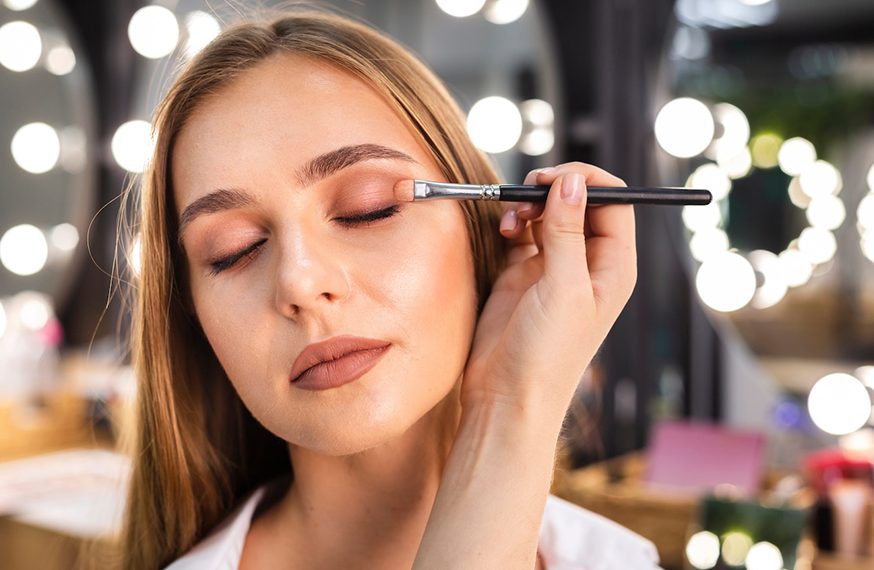 Maquillaje aplicado con brocha frente al espejo